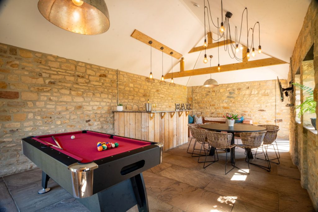 Games room with pool table and bar in The Farmhouse at Greenbank Barns.