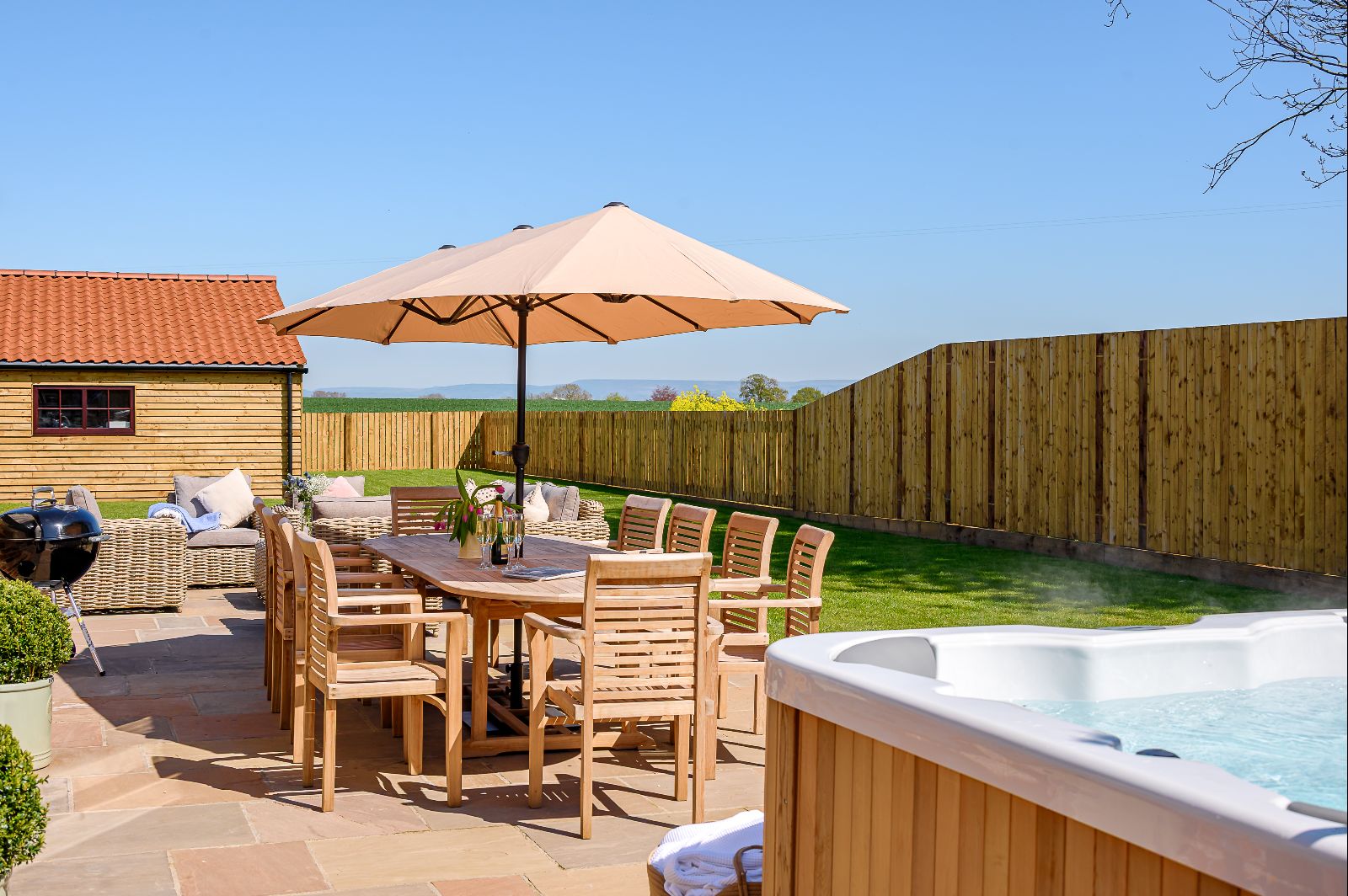 Private garden with hot tub and outdoor seating at the Big Green Barn in North Yorkshire.