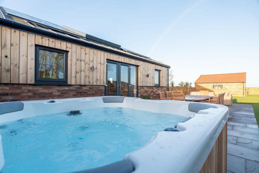Outdoor hot tub at Field Cottage, a self-catering holiday cottage, set within a fenced private area.