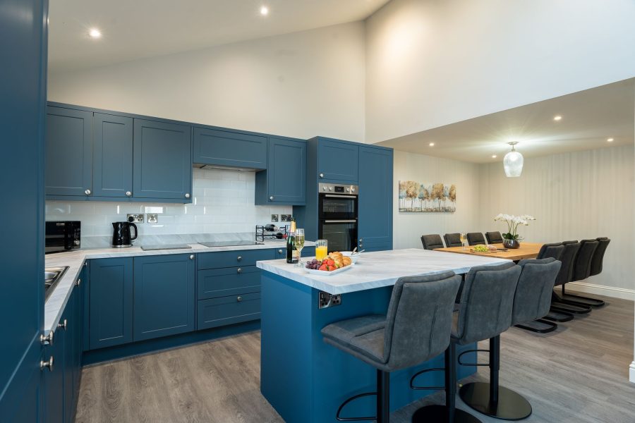 Modern open-plan kitchen and dining area at Field Cottage with island seating.