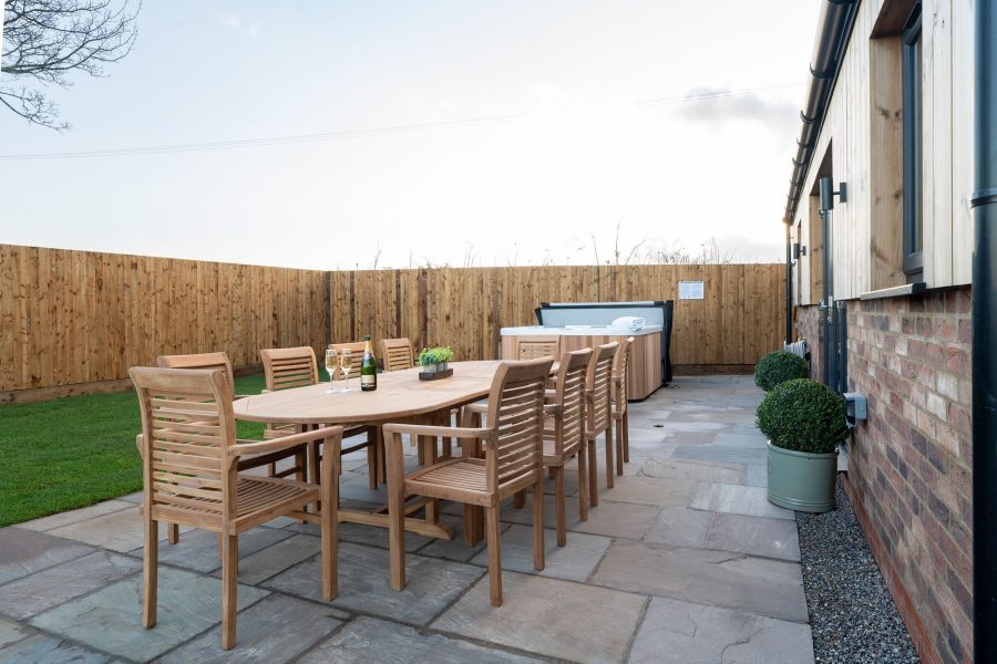 Private outdoor patio dining area at Field Cottage with wooden table and chairs.
