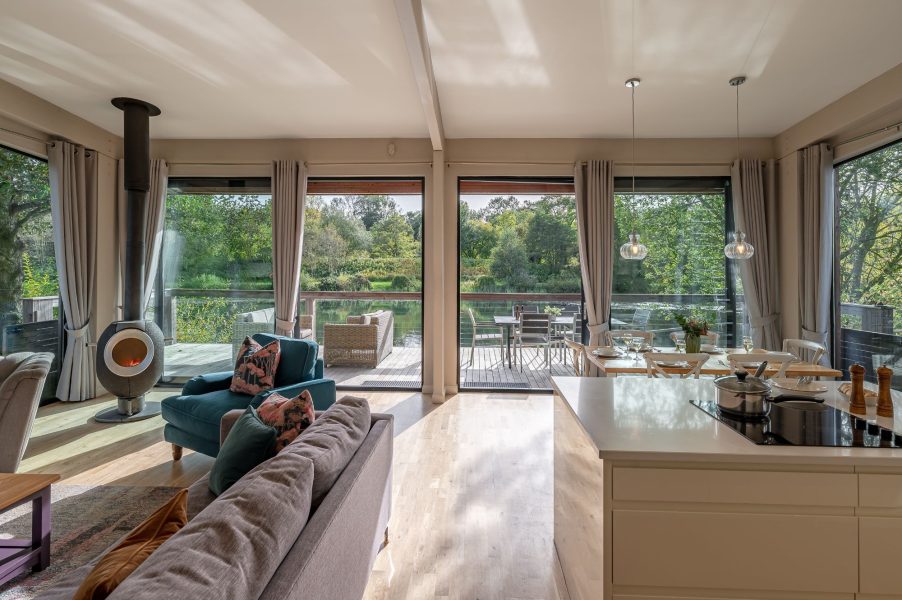 Open-plan kitchen and dining space with floor-to-ceiling windows and lakeside views in Finley Lodge at Brompton Lakes.