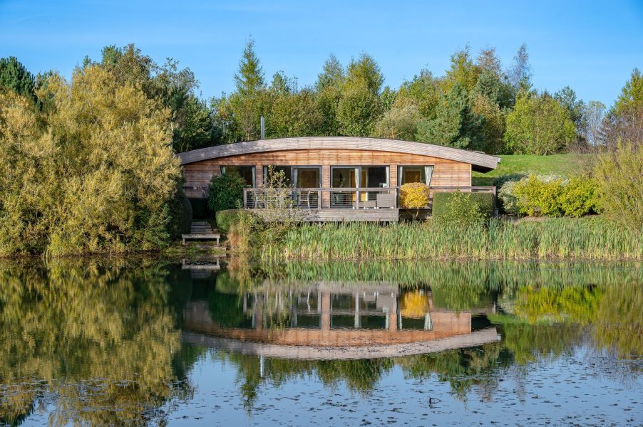Exterior view of Juniper lodge at Brompton Lakes with private decking and tranquil water views in North Yorkshire.
