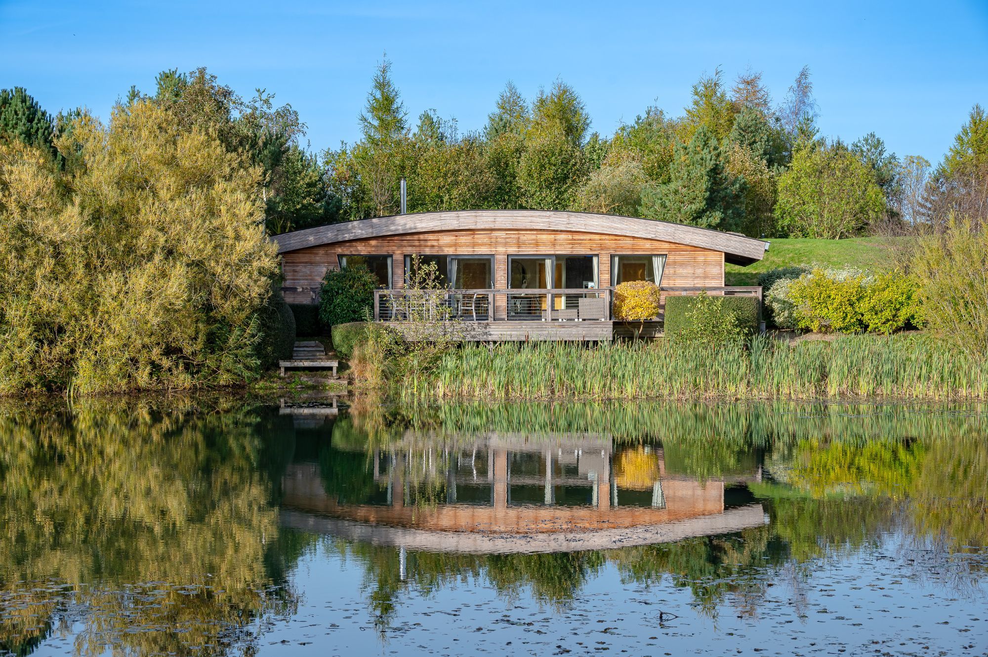 Exterior view of Juniper lodge at Brompton Lakes with private decking and tranquil water views in North Yorkshire.
