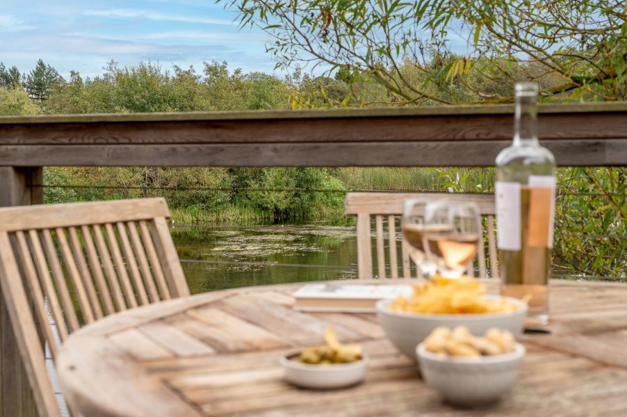 Lakeside setting at William lodge at Brompton Lakes with wine, snacks and tranquil water views from private decking.