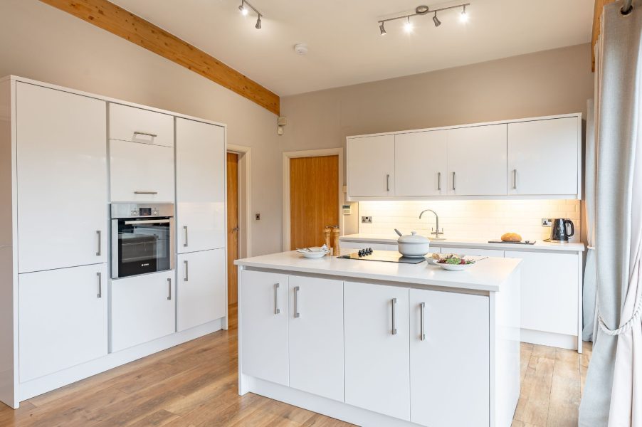Bright and fully equipped kitchen in Charlie lodge with island unit and modern design at Brompton Lakes.