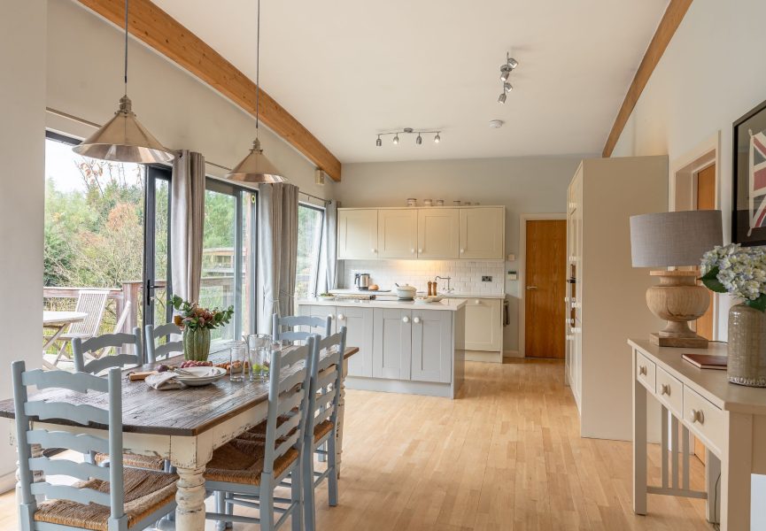 Modern kitchen with island and dining area and lake views in Iris lodge at Brompton Lakes.