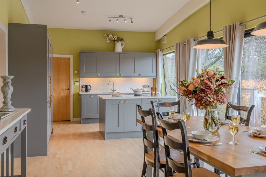 Modern, fully equipped kitchen at Louis lodge with island, grey cabinetry and dining area.