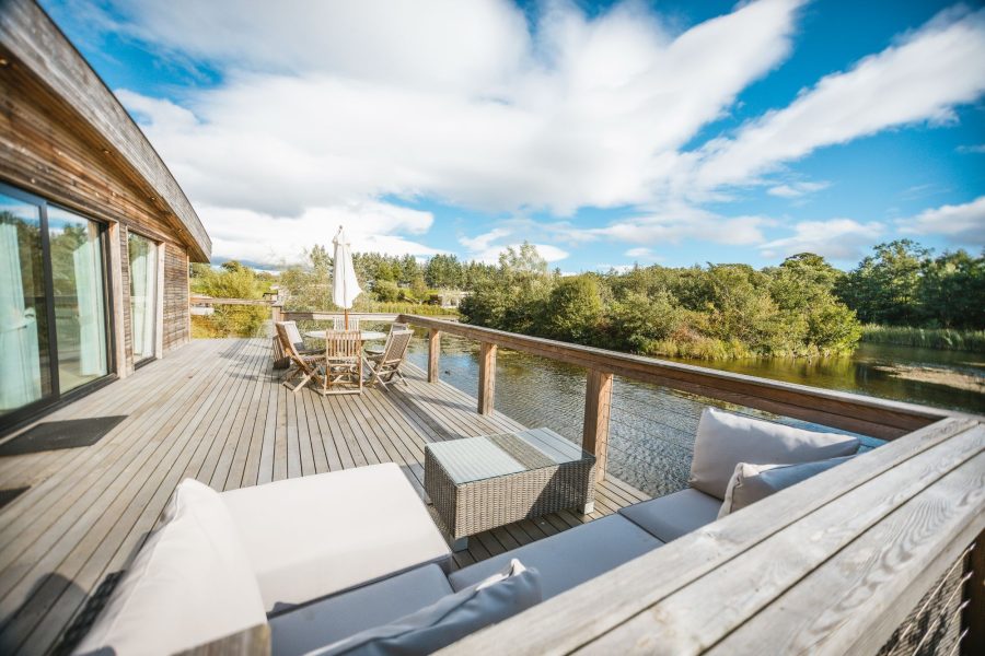Lulu lodge at Brompton Lakes with spacious wooden decking, outdoor seating and scenic lakeside views in North Yorkshire.