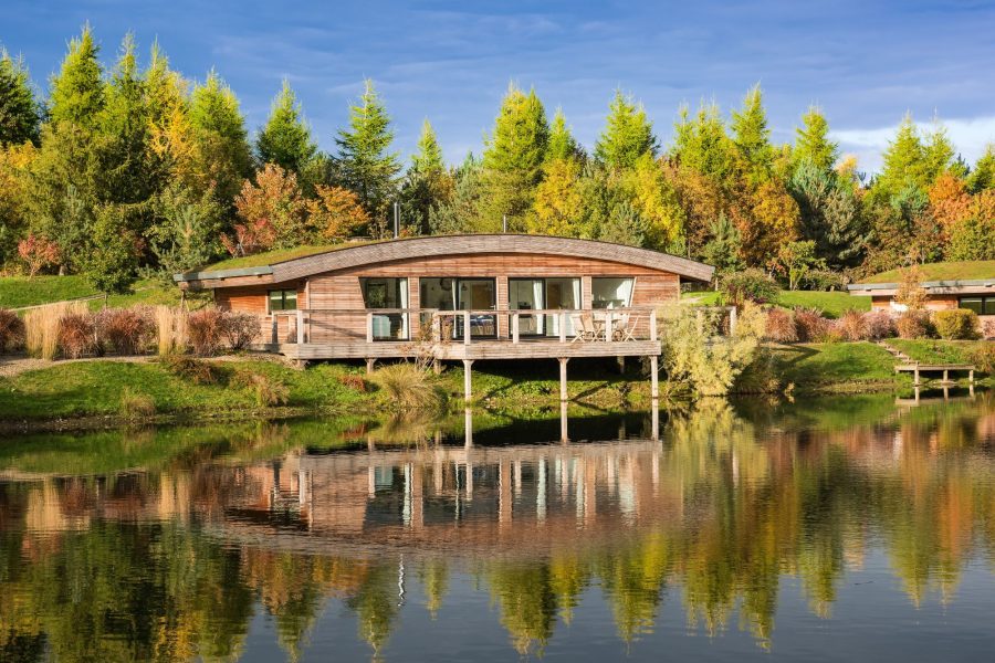 Exterior of Lulu lodge at Brompton Lakes with private decking overlooking tranquil water and wildlife.