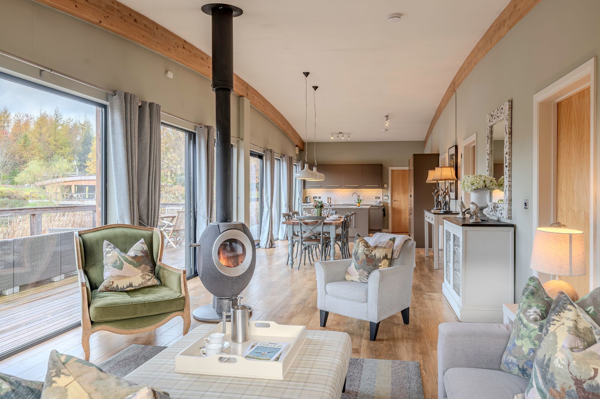 Open-plan kitchen, living and dining area in Rebecca lodge at Brompton Lakes with lake views and private decking.