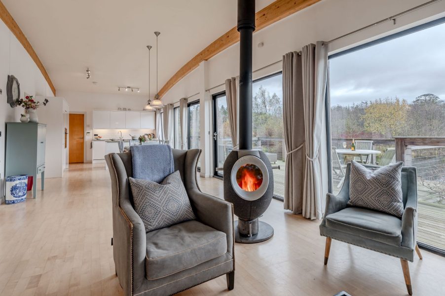 Open-plan living and seating area in Lulu lodge, Brompton Lakes with high ceilings and large glass doors to decking.