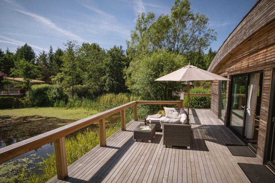 Private decking at Lola lodge with outdoor seating and lake views at Brompton Lakes, Yorkshire.