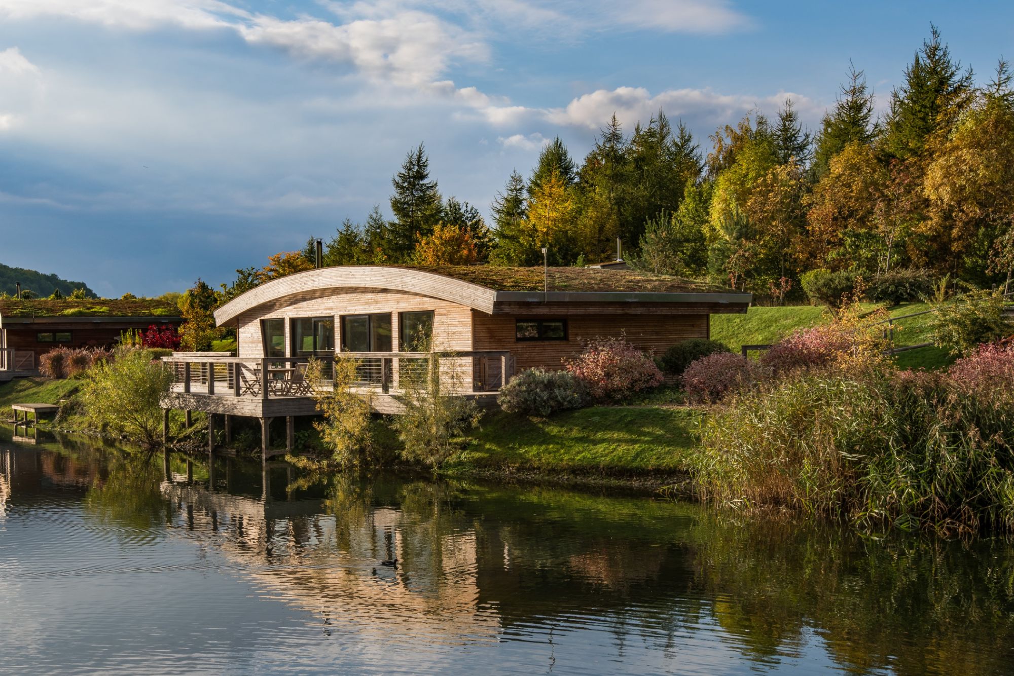 Exterior of Florence lodge at Brompton Lakes overlooking tranquil lake with luxury lodges in Yorkshire countryside.