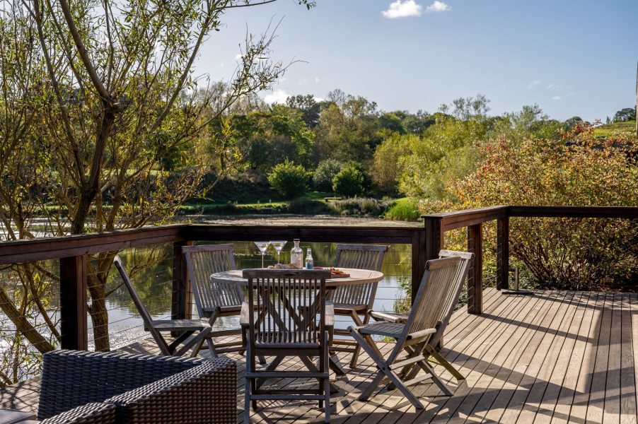 Private decking at Florence lodge at Brompton Lakes with scenic lake views and outdoor seating.