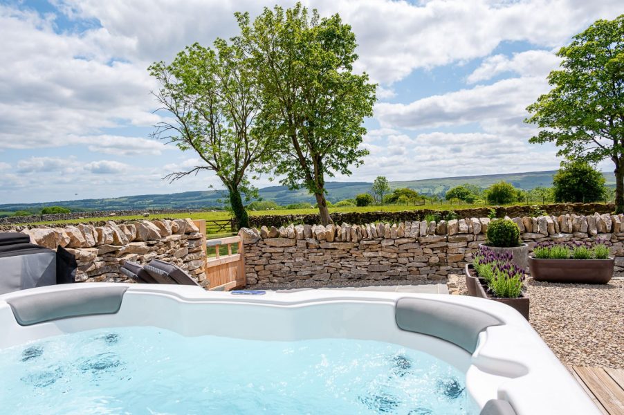 Hot tub at The Stables in North Yorkshire with panoramic countryside views and private stone terrace.