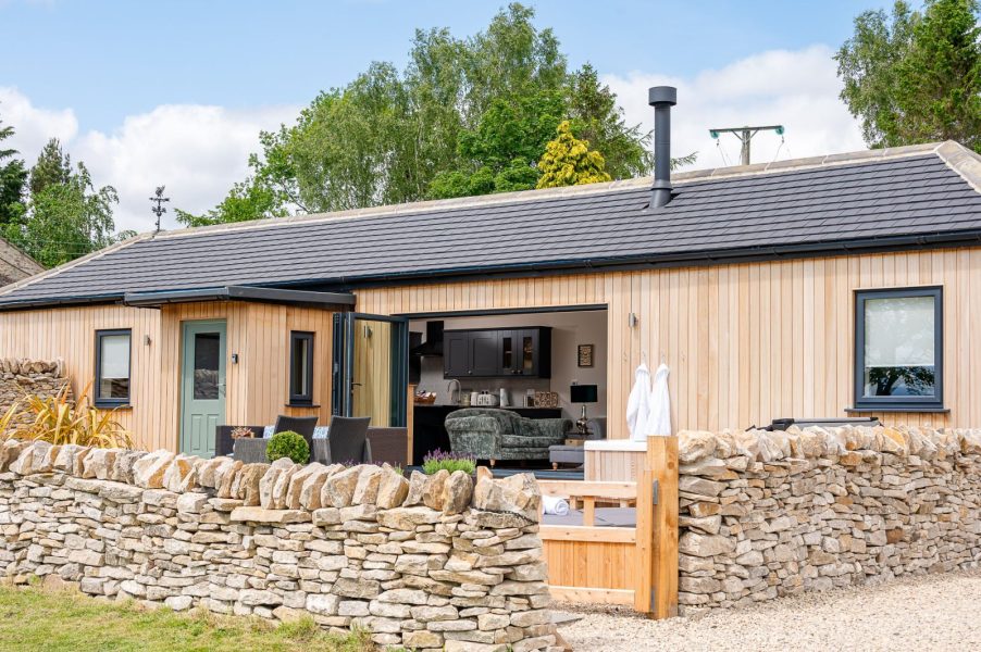 Exterior of The Stables in North Yorkshire with enclosed patio, hot tub and seating area.