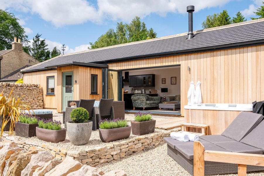 Exterior of The Stables in North Yorkshire with enclosed patio, hot tub and seating area.