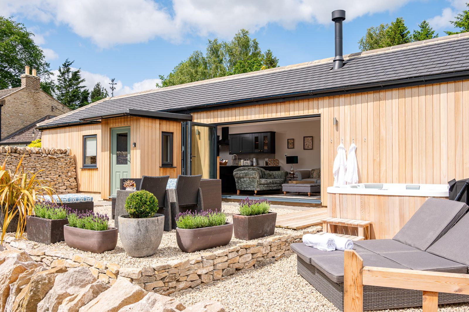 Exterior of The Stables in North Yorkshire with enclosed patio, hot tub and seating area.