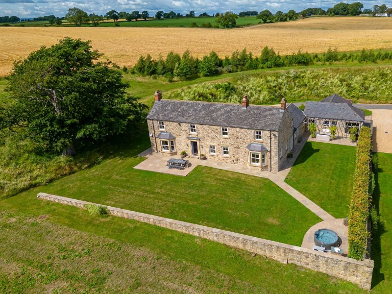 Aerial view of Greenbank Barns in North Yorkshire with traditional stonework, gardens, hot tub and outdoor seating areas.