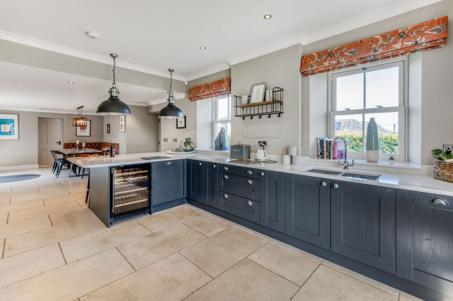 Modern farmhouse kitchen at The Farmhouse at Greenbank Barns with wine fridge, integrated appliances and large windows.