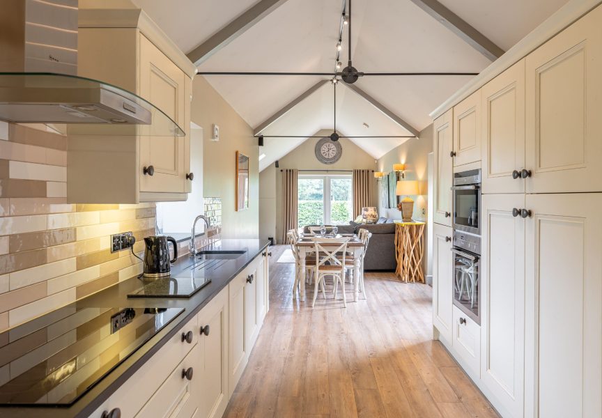 Open-plan living and kitchen area with dining table and cosy lounge in Austin holiday cottage.