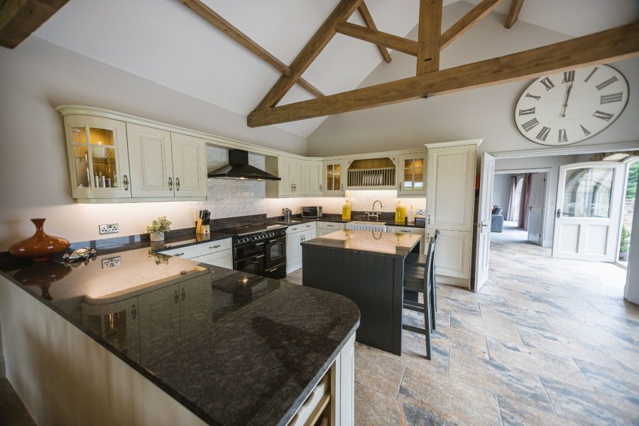 Modern country kitchen with island and vaulted ceiling in Kingfisher holiday cottage.