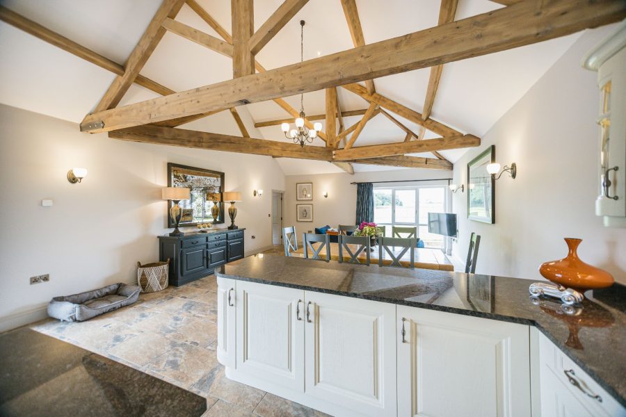 Modern country kitchen with island and vaulted ceiling in Kingfisher holiday cottage.