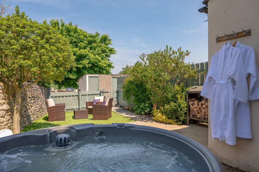 Woodcroft Cottage garden with hot tub, outdoor seating and enclosed private space for relaxing holiday breaks.