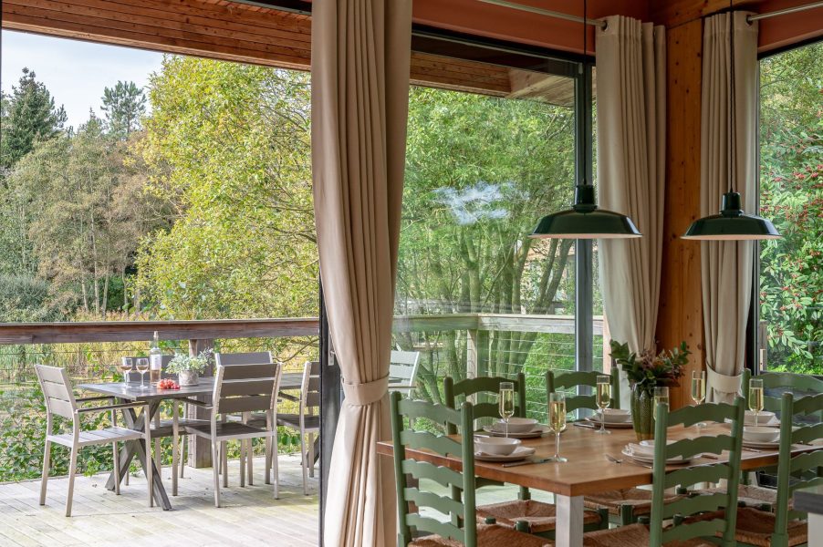 Dining area at Cara lodge with direct access to outdoor decking and al fresco seating at Brompton Lakes, Yorkshire.
