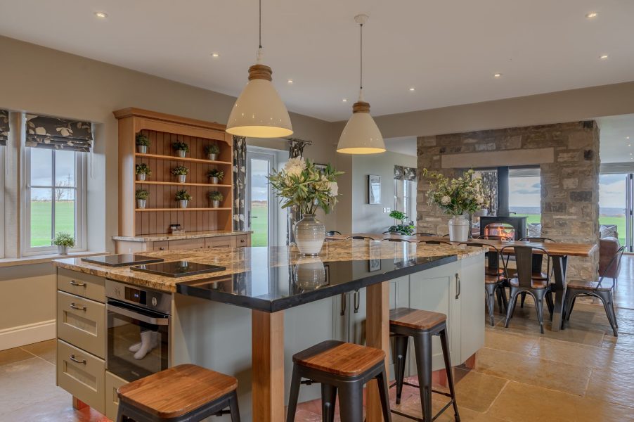 Modern kitchen at Waterloo Lodge with granite island, pendant lighting and farmhouse-style cabinetry.