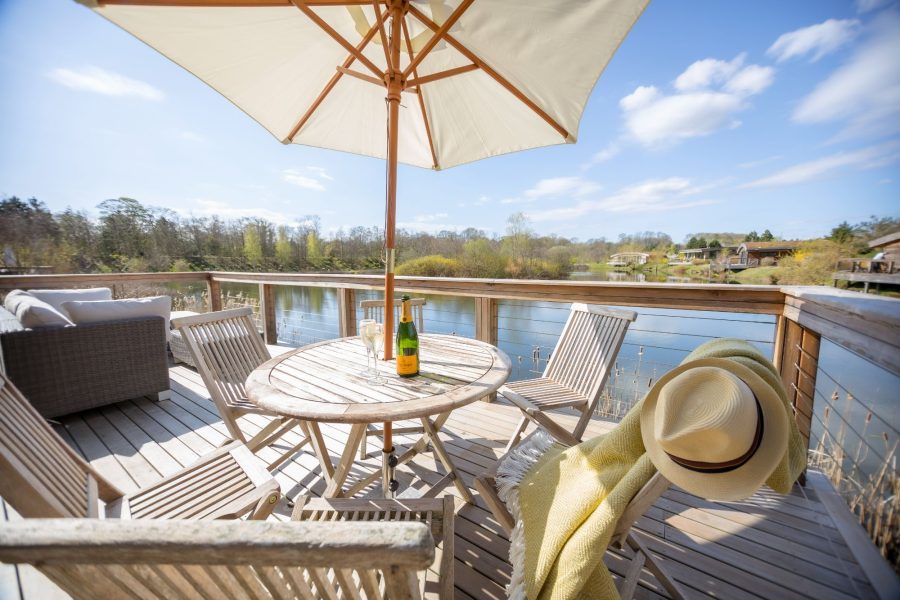 Private decking area in Coco lodge at Brompton Lakes with outdoor seating and lakeside setting.