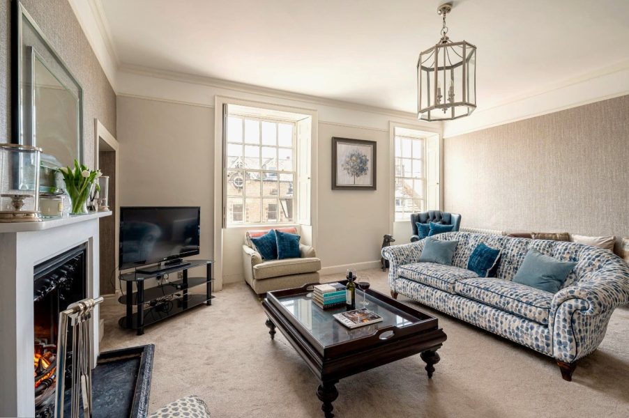 Porte House living room with open fireplace, coffee table and comfortable seating area.