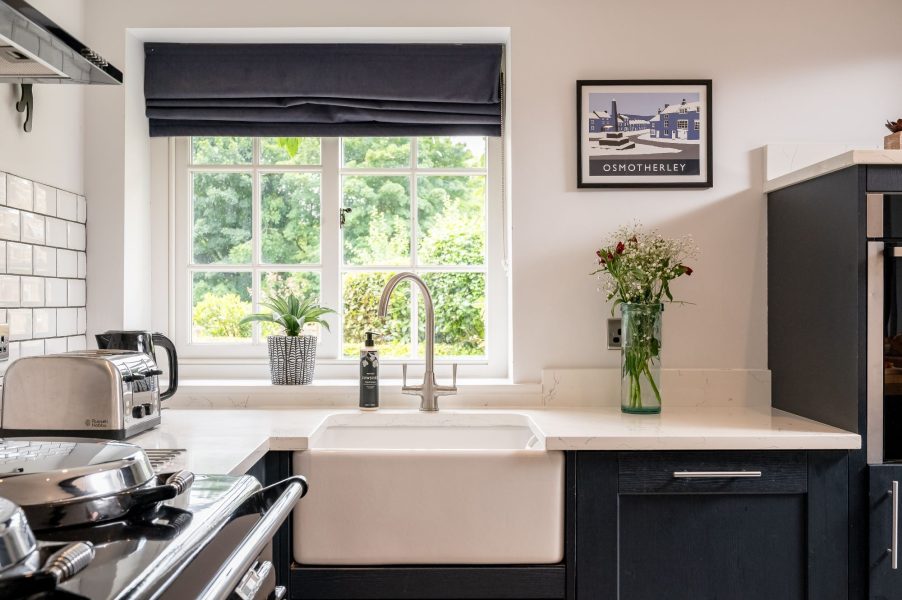 Bright kitchen in Paddock View, Osmotherley with farmhouse sink, window views and decorative styling.
