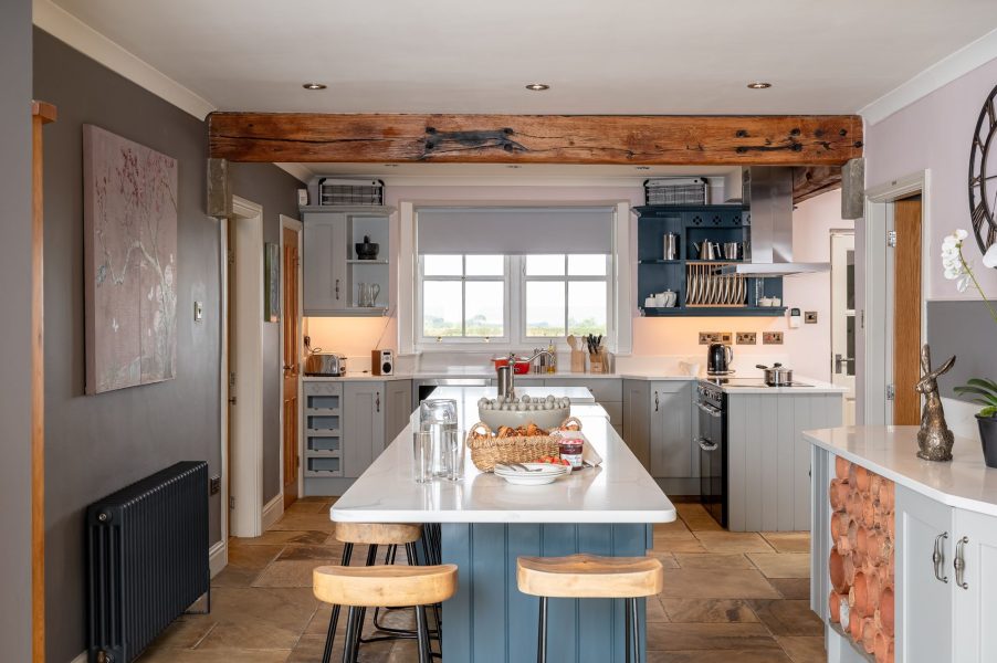 Modern farmhouse kitchen with island and breakfast stools in Harelands cottage.