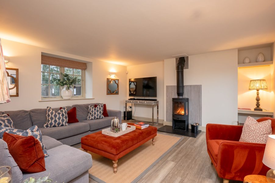 Cosy living room with wood burning stove, large sofa and stylish décor in Henry