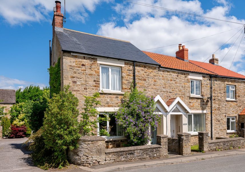 Traditional stone exterior of Woodcroft Cottage in Hudswell with charming entrance, cottage garden and countryside setting.