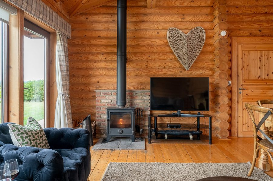 Penhill lodge lounge with seating, log burner, TV and garden access.
