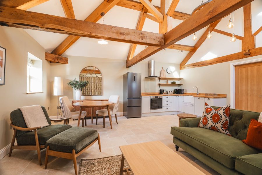 Open-plan living area in Whitwell Nook, North Yorkshire with exposed beams, kitchen, and dining space.