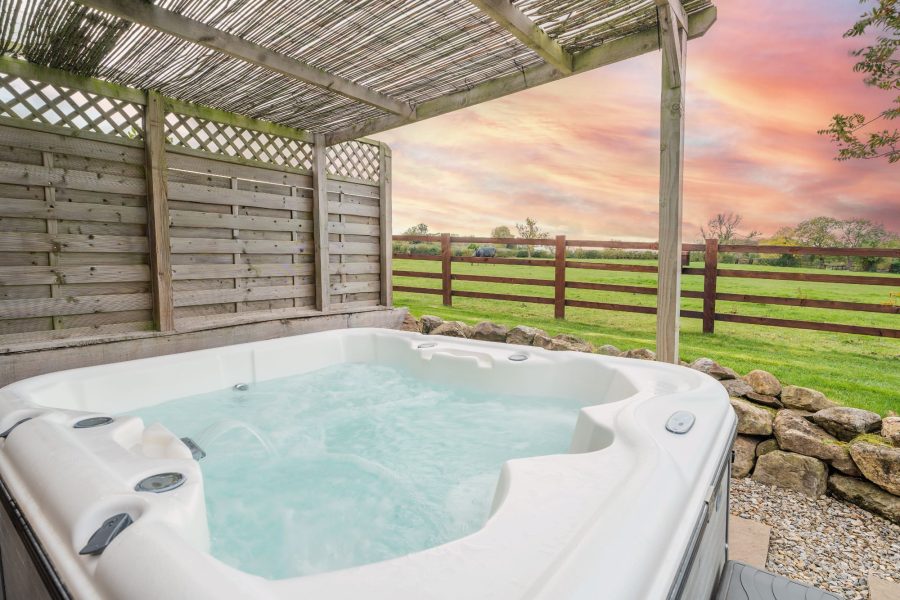 Outdoor hot tub at Rosina lodge with countryside views.