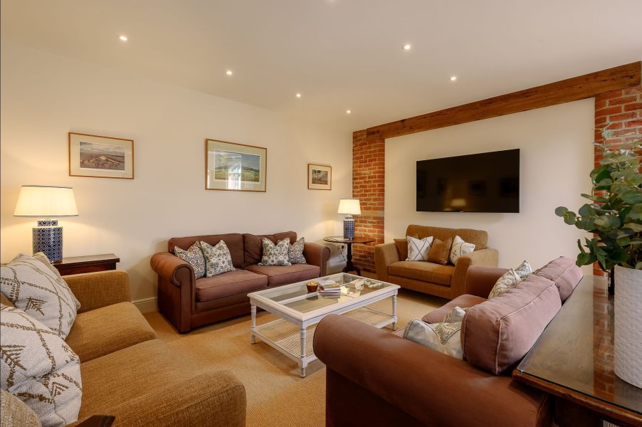Comfortable living room in Hollins Barn with sofas, coffee table and wall-mounted TV.