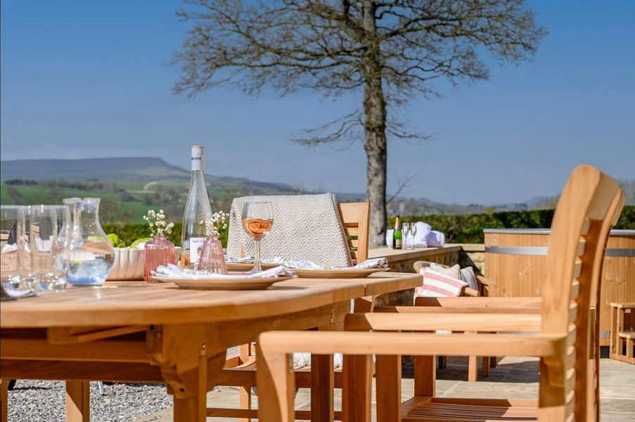 Alfresco dining at Hollins Barn with countryside views and stylish outdoor furniture.