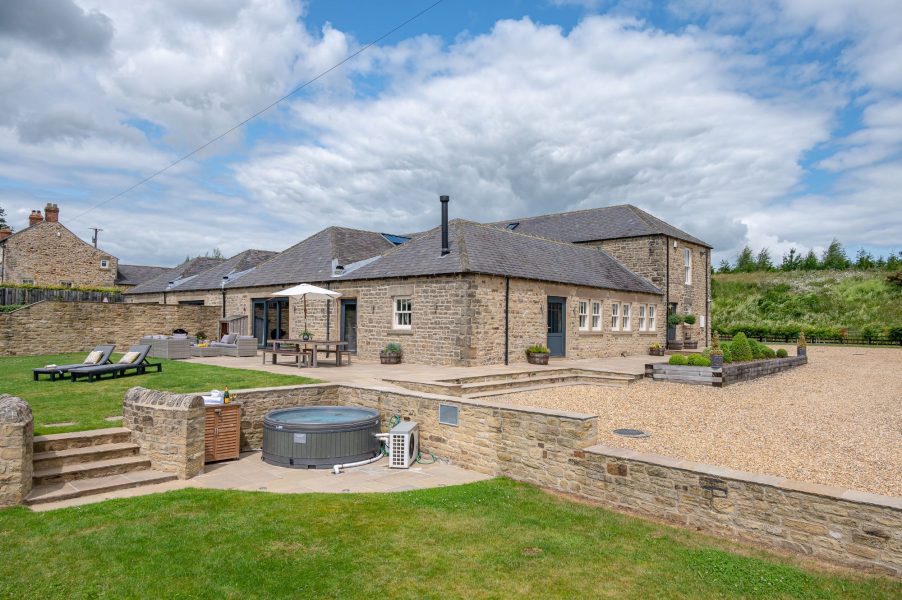 Spacious countryside retreat at Dexter featuring a private hot tub, outdoor dining area, and beautifully landscaped gardens