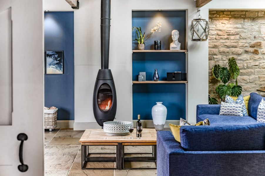 Cosy lounge area at Dexter with wood-burning stove, character stone walls, and contemporary styling