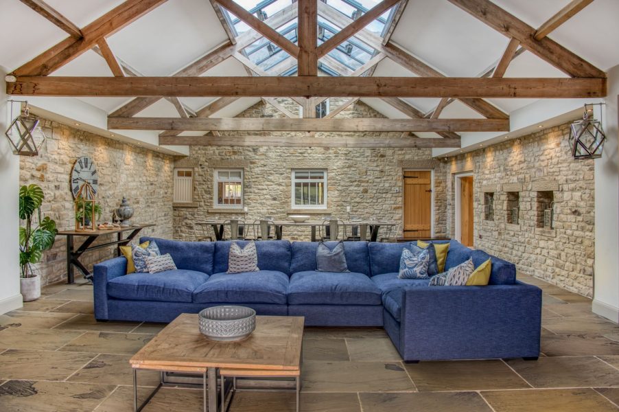Impressive open-plan living space at Dexter with exposed beams, large skylights, and a generous seating area perfect for groups