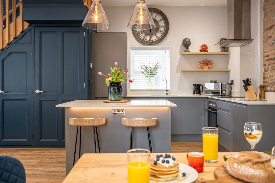 Contemporary kitchen with island, pendant lighting and breakfast setup in The Old Tack Room.