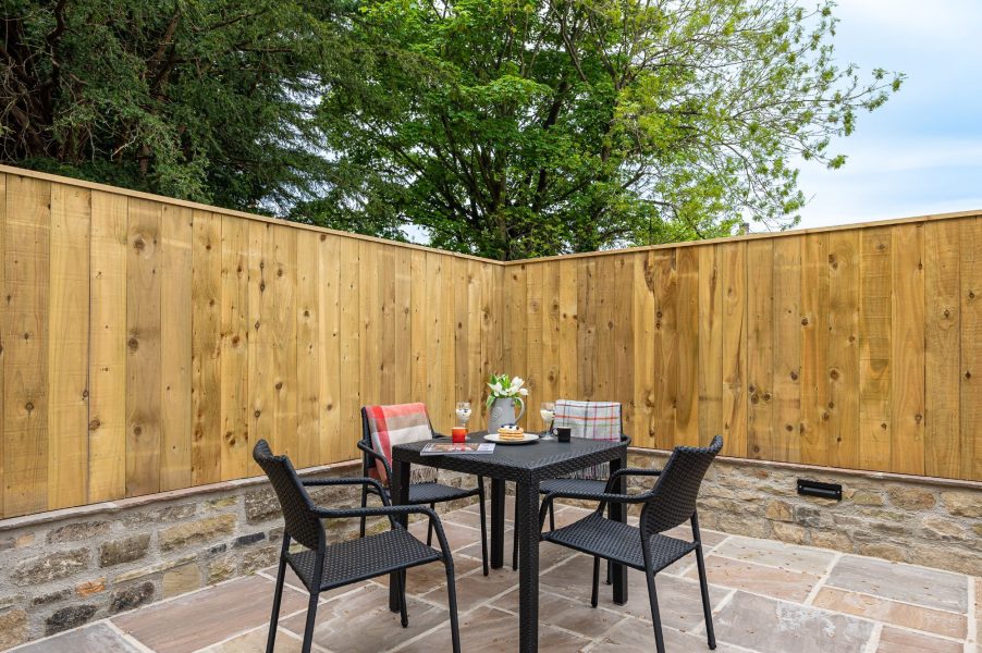 Private outdoor patio with table, seating and enclosed garden area in The Old Tack Room.