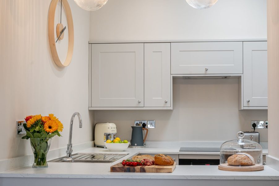 The Swaledale stylish kitchen detail with wooden worktop, fresh flowers and artisan bread display.