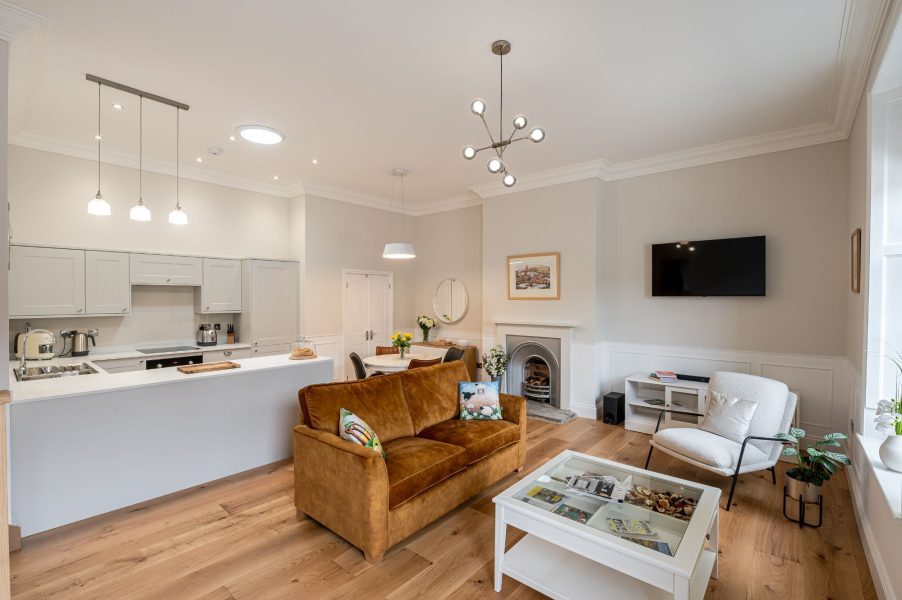 The Wensleydale spacious open-plan living area with kitchen, dining space, brown sofa and contemporary lighting.
