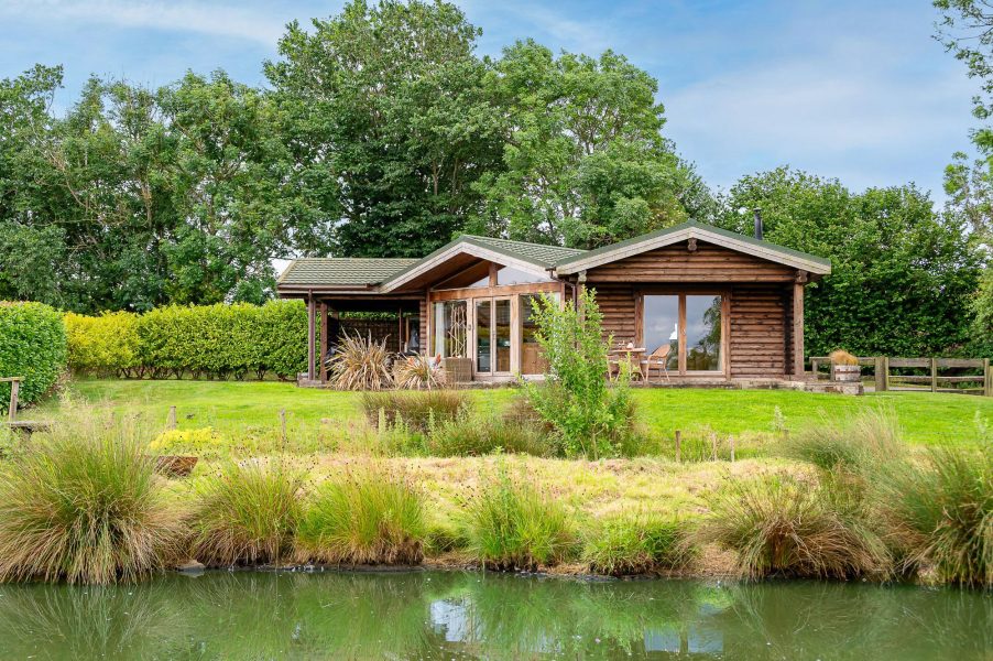 Exterior of Lillie lodge with large lawn and countryside setting at Sun Hill Lodges.